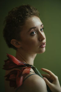 Close-up portrait of young woman against gray background