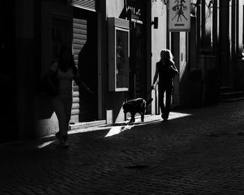 People walking on footpath in city