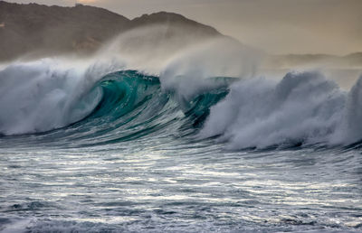 Sea waves splashing against sky