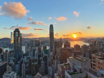 Modern buildings against sky during sunset