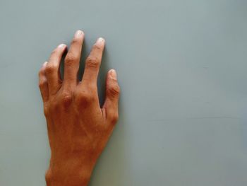 Close-up of hand against wall