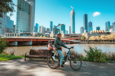 Rear view of woman sitting on bridge