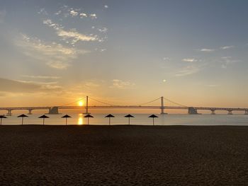 Bridge over sea against sky during sunrise 