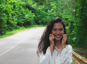 Portrait of smiling young woman on road