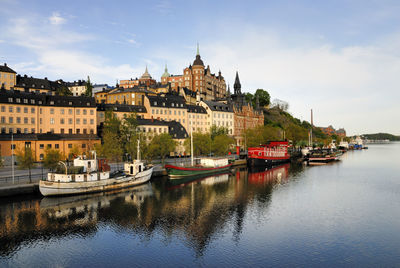 Buildings by river against sky