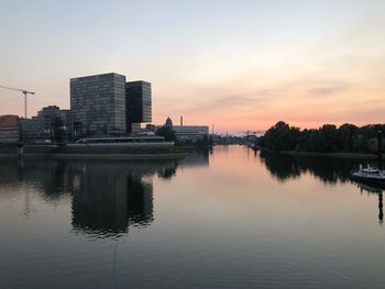 Reflection of buildings in river during sunset