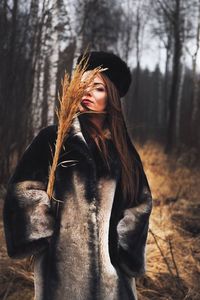 Woman standing by tree trunk