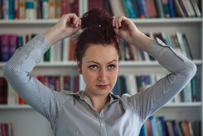 Portrait of young woman with arms raised