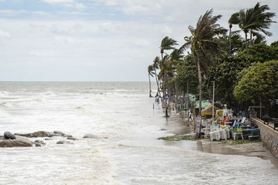 People at beach against sky