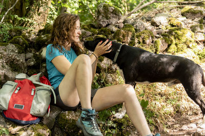 Woman relaxing and resting on a mountain trail with her dog.