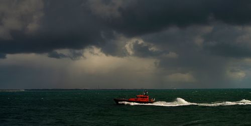 Boat sailing in sea against sky