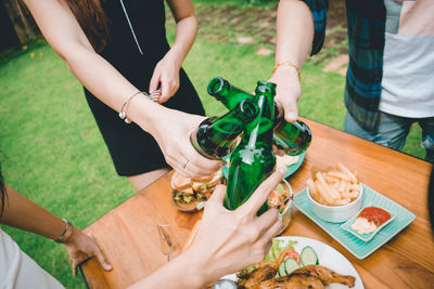 Midsection of woman holding drink on table