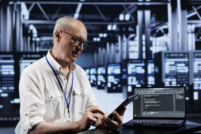 Side view of man using digital tablet in office