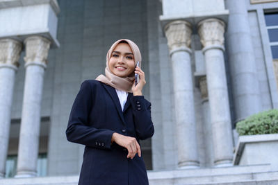 Portrait of smiling young man using mobile phone