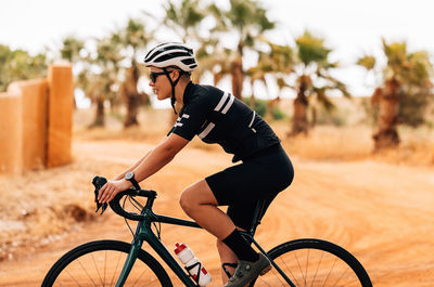 Low section of man riding bicycle on field