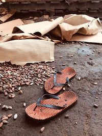 High angle view of slippers by pebbles on road