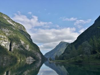 Scenic view of lake by mountains against sky