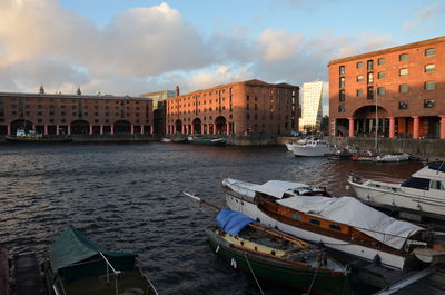 Sailboats moored on canal against buildings in city