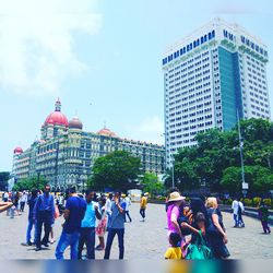 People at town square with city in background