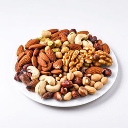 Close-up of peanuts in plate on white background