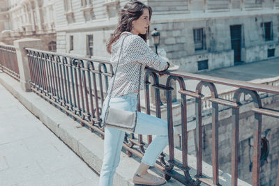 Side view of woman standing by railing