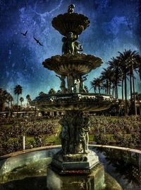 Fountain against cloudy sky