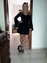 Portrait of smiling young woman standing at home