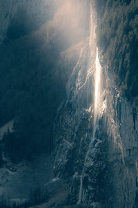 Low angle view of lightning over mountains against sky