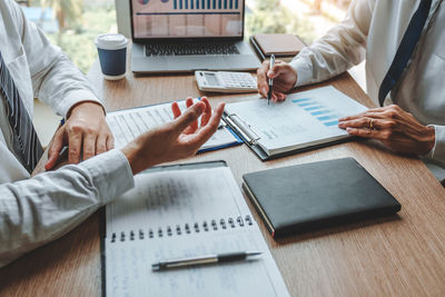 Midsection of business colleagues working at table