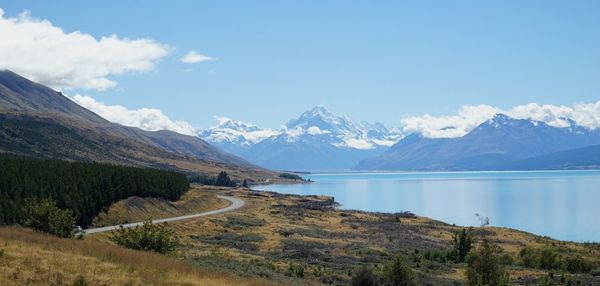 Scenic view of lake and mountains against blue sky