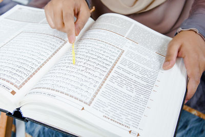 Midsection of woman reading book