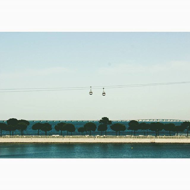 water, transportation, sky, tranquil scene, tranquility, sea, scenics, nature, transfer print, mode of transport, nautical vessel, beauty in nature, auto post production filter, clear sky, lake, connection, power line, copy space, waterfront, river