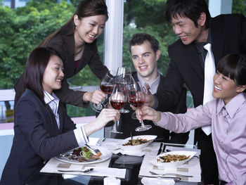 Colleagues with drinks at restaurant during meeting