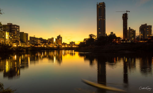 Reflection of buildings in city at sunset