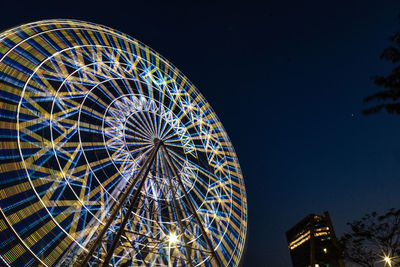 Low angle view of illuminated ferris wheel against sky at night