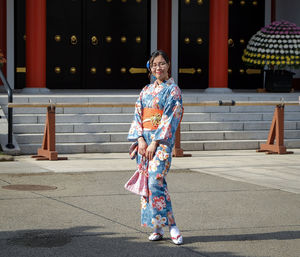 Portrait of woman standing against built structure