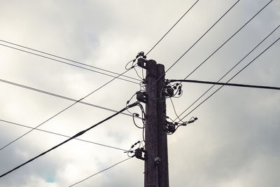 Low angle view of electricity pylon against sky