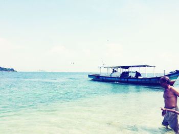 People sitting on sea against sky