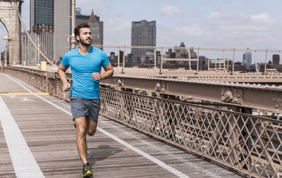 Usa, new york city, man running on brooklyn brige