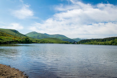 Scenic view of lake by mountains against sky