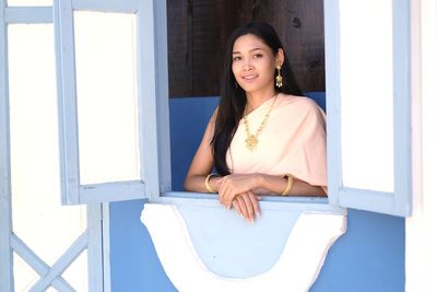 Portrait of beautiful woman in thai clothing seen through window