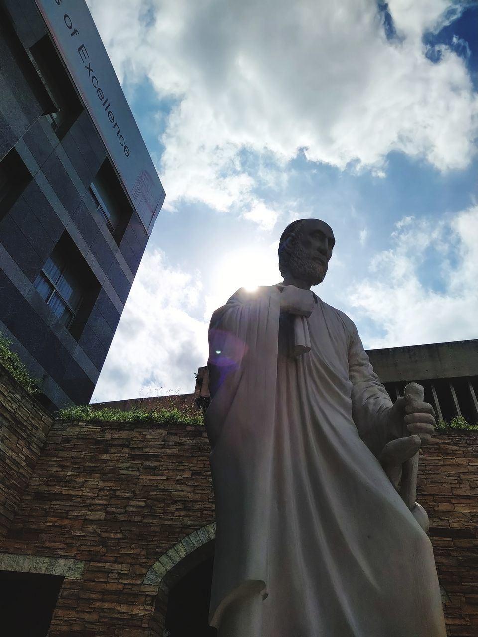 architecture, sky, built structure, cloud - sky, art and craft, human representation, building exterior, low angle view, sculpture, representation, statue, male likeness, day, building, nature, creativity, religion, spirituality, belief, no people, outdoors, fine art statue