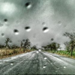 Empty road with trees in background