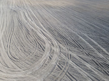 Full frame shot of tire tracks on sand