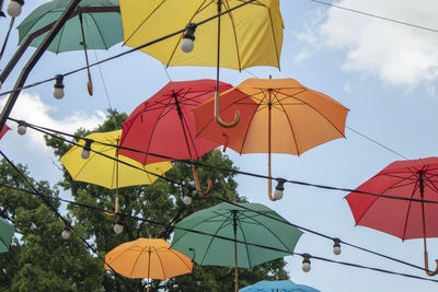 Low angle view of umbrellas hanging against sky