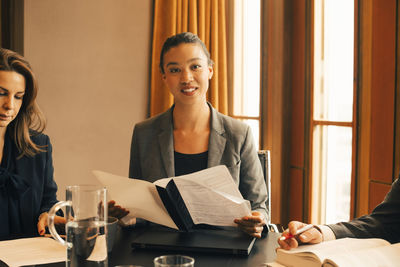 Portrait of a smiling young woman sitting on table