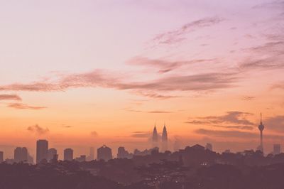 Silhouette of city against sunset