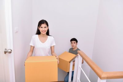 Portrait of couple adjusting boxes in new home