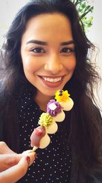 Portrait of smiling young woman holding flower