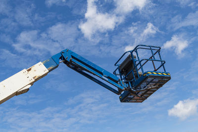 Low angle view of crane against blue sky